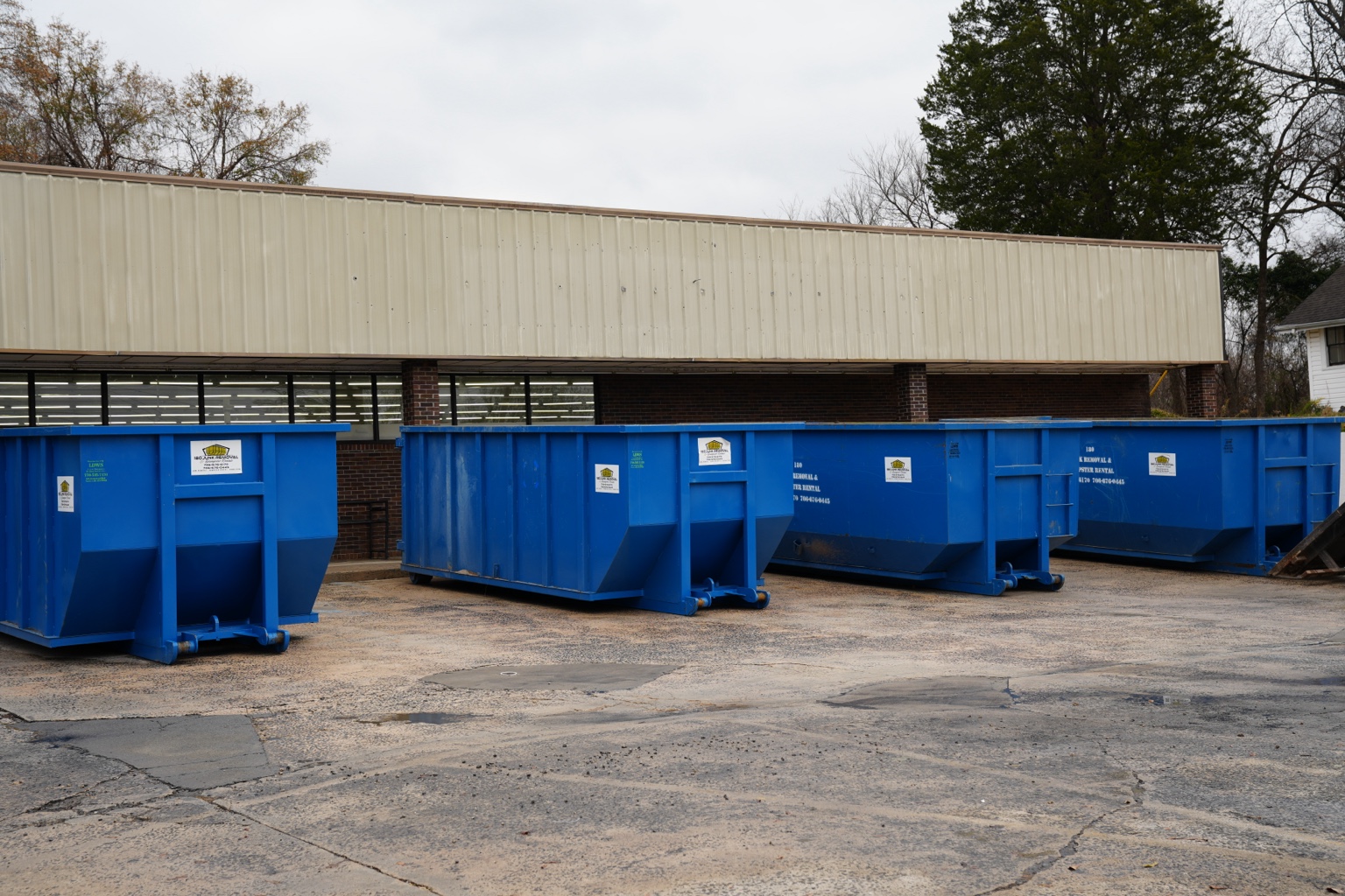 Blue roll-off dumpsters in the 180 Junk Removal fleet