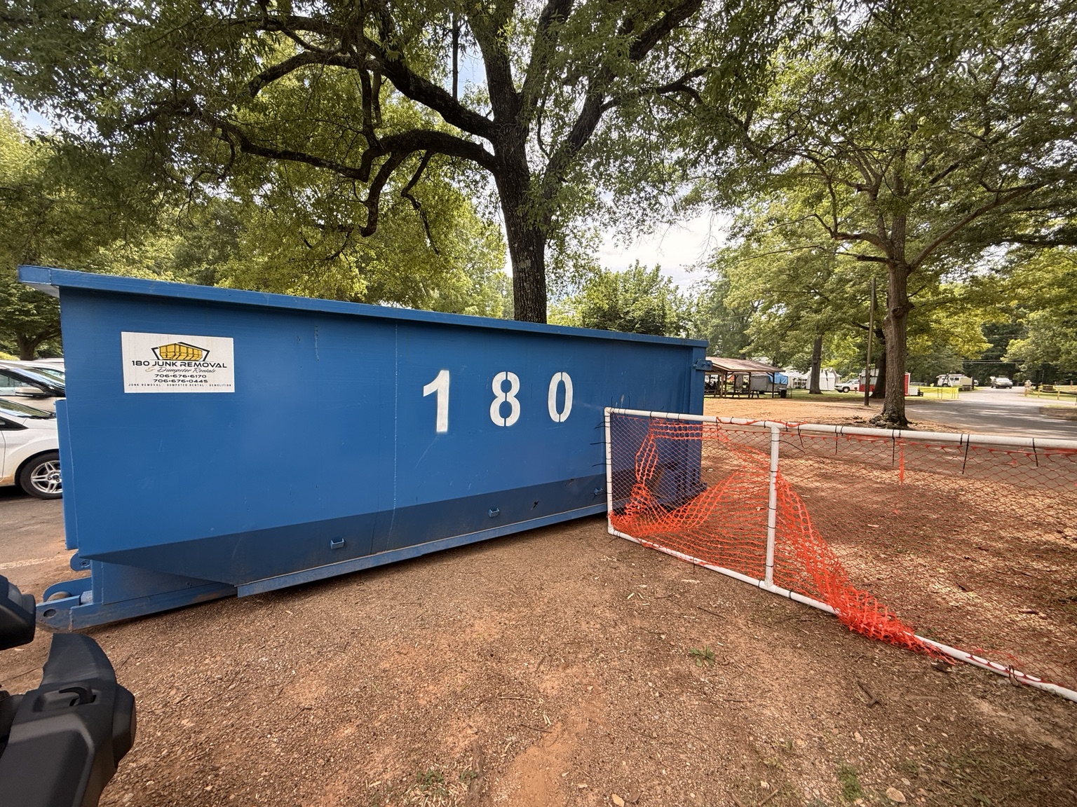 Blue 180 Junk Removal roll-off dumpster placed at a customer site